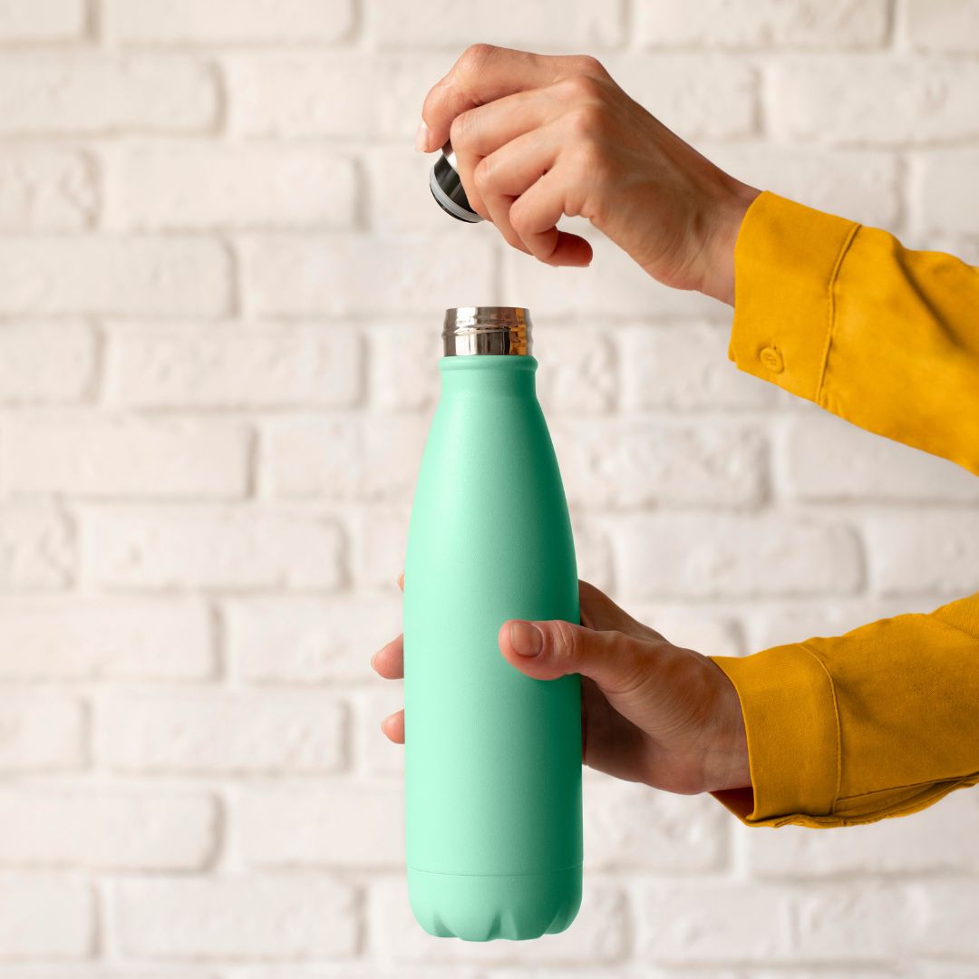 Mani che aprono una bottiglia thermos per l'acqua