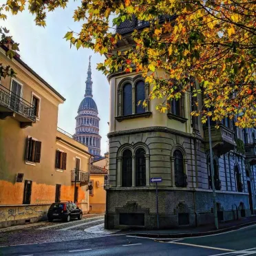 Cupola di Novara che spunta in mezzo ad altri edifici per le strade di Novara